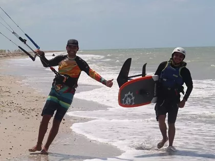 rider learning kitefoil in Mayapo La Guajira with instructor using radio helmet